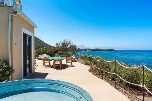 a house with a swimming pool next to the ocean at Torre dei 7 Frati in Cefalù