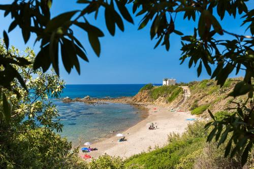 a beach with people on the sand and the ocean at Torre dei 7 Frati in Cefalù