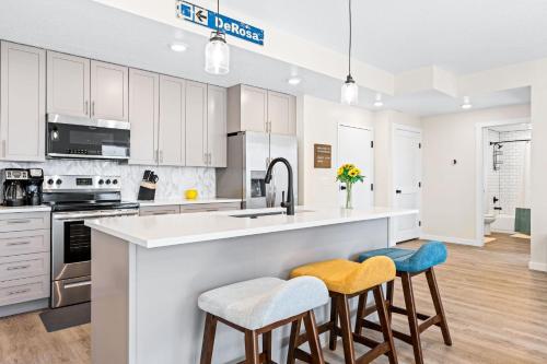 une cuisine avec des placards blancs et un grand îlot avec des tabourets dans l'établissement PonDerosa Place condo, à Saint George