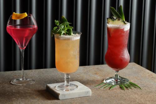 three cocktails are sitting on a table with at WE HOTEL RIVERFRONT in Bang Su