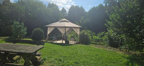 a gazebo in a field with a picnic table at Wohnmobilstellplatz in Mecklenburg-Vorpommern - ab Juni Dixi WC in Carpin