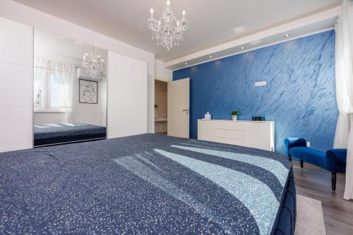 ein blaues Schlafzimmer mit einem Bett und einer blauen Wand in der Unterkunft Filip in Crikvenica