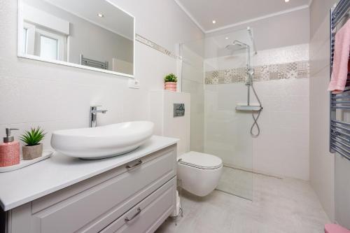 ein weißes Badezimmer mit Waschbecken und Dusche in der Unterkunft Filip in Crikvenica