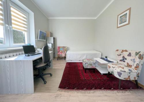 een witte kamer met een bureau en een bed met een computer bij Vintage 70 Villa in Šiauliai