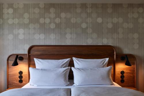a bedroom with a bed with white pillows at Parkhotel Gütersloh in Gütersloh