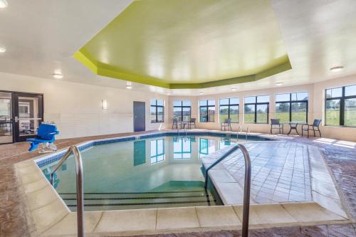 a pool in a building with a swimming pool at Holiday Inn Express & Suites Kansas City Airport by IHG in Kansas City
