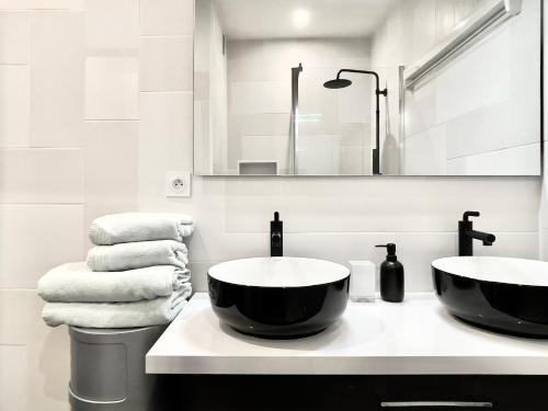 - une salle de bains avec 2 lavabos et des serviettes sur un comptoir dans l'établissement Superbe Appartement côté Jardin, à Paris