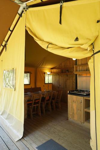 une tente avec une table et des chaises dans une chambre dans l'établissement Tente Safari Eco Lodge 6 Personnes, à Castillon-Debats