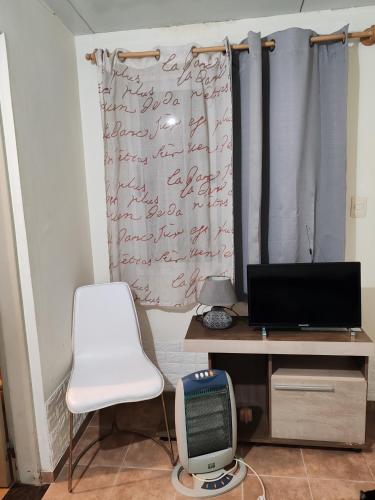a desk with a computer and a chair in a room at Apto independiente al fondo de casa familiar in Montevideo