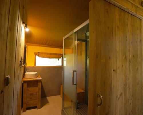 a bathroom with a glass shower and a sink at Tente Safari Eco Lodge 6 Personnes in Castillon-Debats