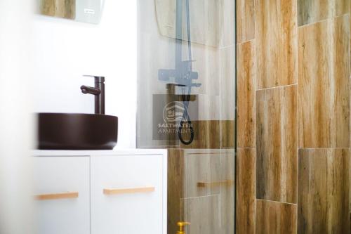a bathroom with a shower with a glass door at Saltwater Apartments in Ocna-Mureşului