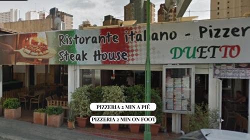 a restaurant with a sign in front of a building at Apartamento Completo Torresol V in Benidorm