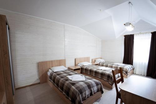 a hotel room with two beds and a table and a table sidx sidx at Hotel Duet in Maydan