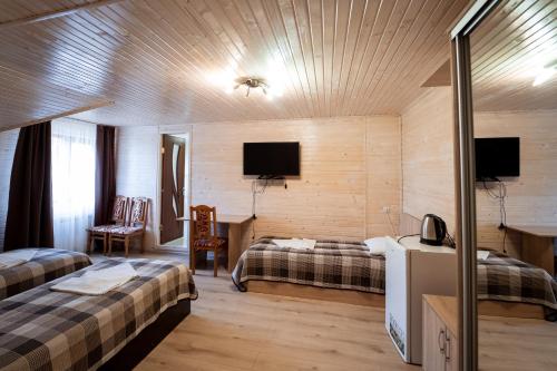 a hotel room with two beds and a tv at Hotel Duet in Maydan