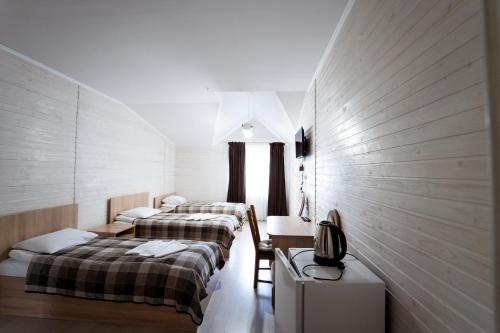 a hotel room with two beds and a television at Hotel Duet in Maydan