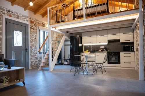 a kitchen and living room with a staircase in a loft at Centro Stone House in Tolo