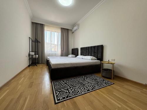a bedroom with a bed and a rug on a wooden floor at Velvet Vouge Hostel in Yerevan
