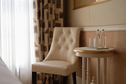 a room with a chair and a table with glasses on it at The Montague On The Gardens in London