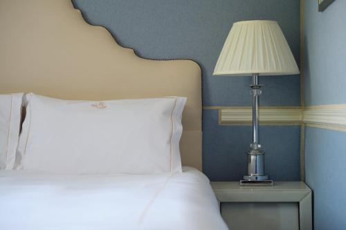a bedroom with a bed and a lamp on a table at The Montague On The Gardens in London