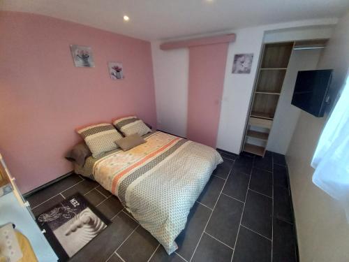 - une chambre avec un lit dans une pièce aux murs roses dans l'établissement studio 8, à Limoges