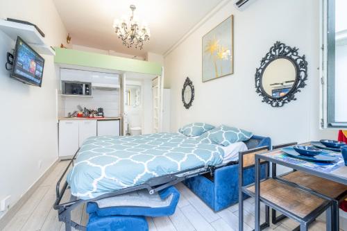 - une chambre avec un lit bleu et une table dans l'établissement Little boudoir of Paris Champs-Elysées, à Paris