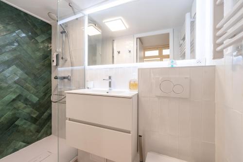 une salle de bain blanche avec un lavabo et une douche dans l'établissement Little boudoir of Paris Champs-Elysées, à Paris