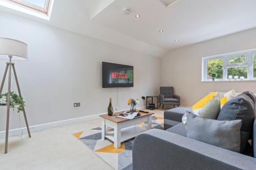 a living room with a couch and a tv at Redhill Hideaway Stylish Spacious Apartment in Redhill