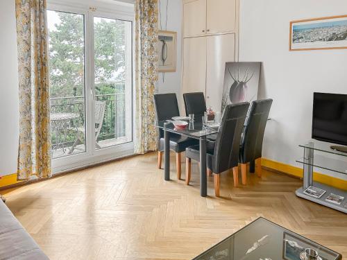 ein Esszimmer mit Tisch und Stühlen und einem Fenster in der Unterkunft Appartement Spacieux et Chic Le Havre, capacité 2 personnes ou famille 3 personnes,1 chambre, baignoire in Le Havre