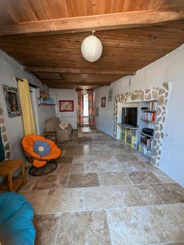- un salon avec un sol en pierre et un plafond en bois dans l'établissement La maison des couleurs, à Sauve