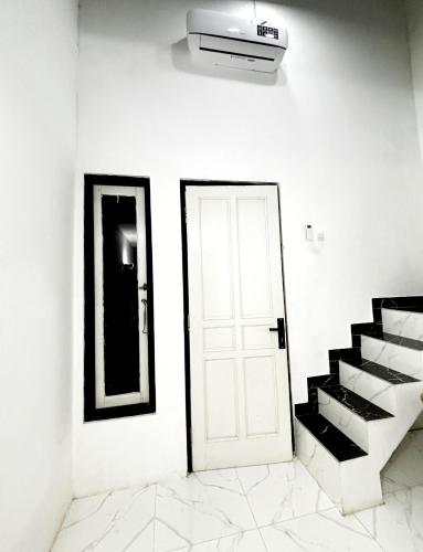 a white room with a white door and stairs at Kost Harian Semarang Murah in Semarang