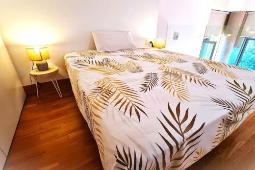a bedroom with a bed with a black and white comforter at BEACH VALENCIA LUXURY E-Arenas 117 Apartment with terrace in Edificio Arenas in Valencia