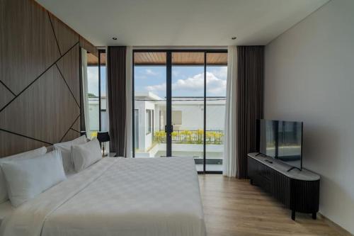 ein Schlafzimmer mit einem großen Bett und einem Fernseher in der Unterkunft Luxury Haven Stunning 2Br in Umalas Canggu in Kerobokan