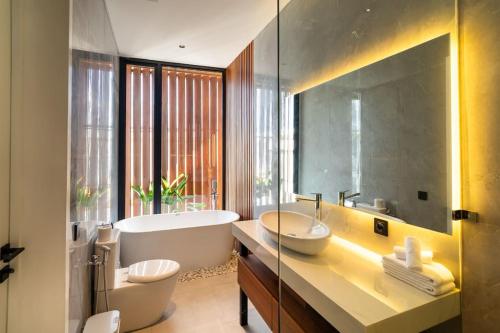 ein Badezimmer mit zwei Waschbecken, einer Badewanne und einer Badewanne in der Unterkunft Luxury Haven Stunning 2Br in Umalas Canggu in Kerobokan
