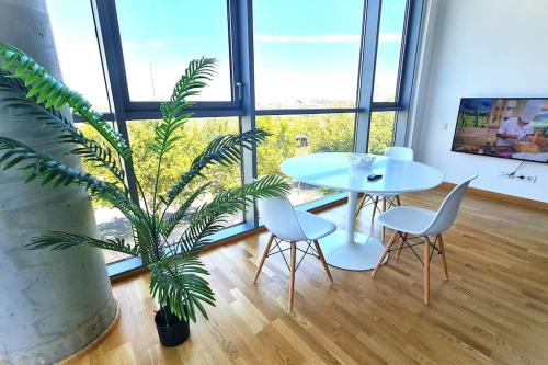 a table and chairs and a potted plant in a room at BEACH VALENCIA LUXURY E-Arenas 117 Apartment with terrace in Edificio Arenas in Valencia