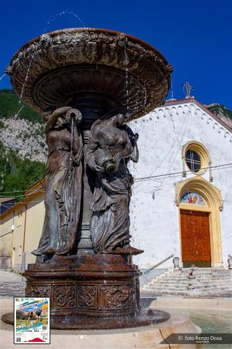 a statue of two people on a fountain in front of a church at Mariella Vernile in Civitella Roveto