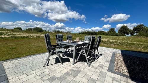 a table with four chairs sitting on a patio at Grünes Seeidyll - direkt am Puddeminer Wiek! in Puddemin