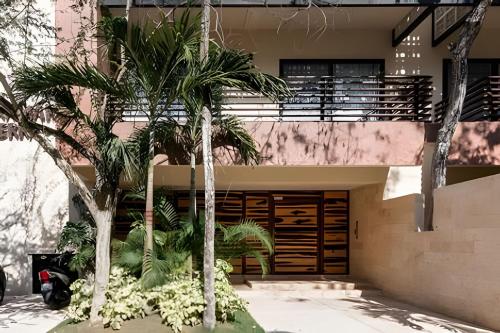 トゥルムにあるCasa de lujo Ka'an Maya acceso SwimUp a la piscinaの建物前のヤシの木がある家