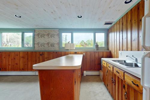 Una cocina grande con gabinetes de madera y fregadero. en Great Pond Retreat, en Killington