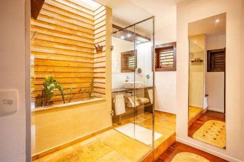 a bathroom with a glass shower and a sink at Villa Niros - Aldeia Jericoacoara in Jericoacoara