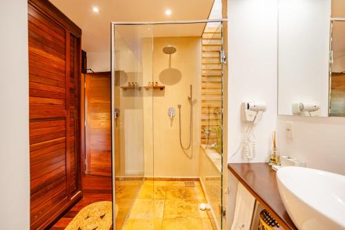 a bathroom with a glass shower and a sink at Villa Niros - Aldeia Jericoacoara in Jericoacoara