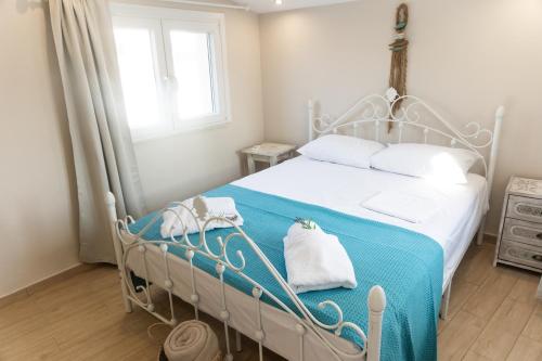 a bedroom with a bed with a blue blanket at Pappous Adreas in Skiathos Town