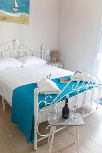 a bedroom with a white bed with a blue blanket at Pappous Adreas in Skiathos Town