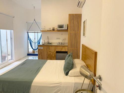 a bedroom with a bed and a kitchen with a microwave at Studios Downtown Cancun in Cancún