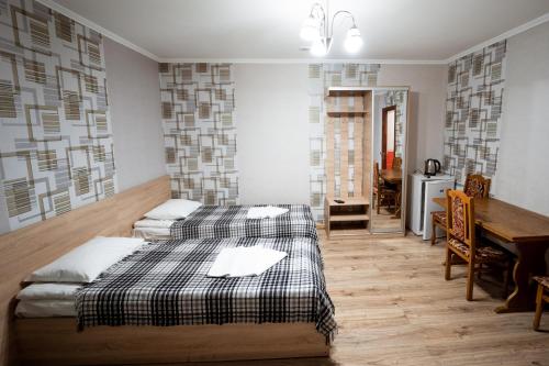 two beds in a room with a table and a dining room at Hotel Duet in Maydan