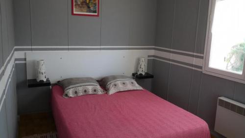 - une chambre avec un lit rose et 2 oreillers dans l'établissement Gite au milieu des vignes g286, à Vidauban