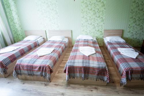 a group of three beds sitting in a room at Hotel Duet in Maydan