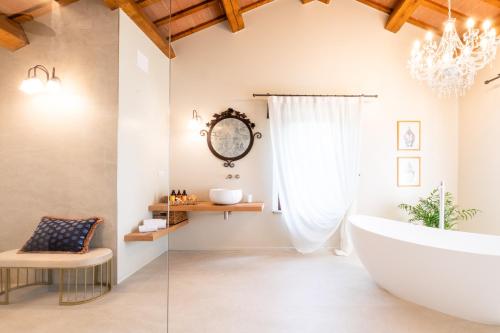 a bathroom with a large tub and a chandelier at Villa Giulia Relais & Spa in Jesolo