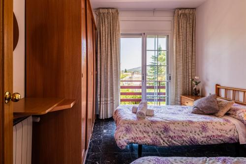 une chambre d'hôtel avec deux lits et une fenêtre dans l'établissement Espacio de paz, ideal para familias Villa Amalia, à Llacuna