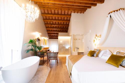 a bedroom with a large white bed and a bathtub at Villa Giulia Relais & Spa in Jesolo