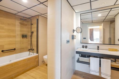 a bathroom with a shower and a toilet and a sink at Melia Alicante in Alicante